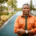 Portrait of senior black man with grey hair, standing on the street, looking at camera.